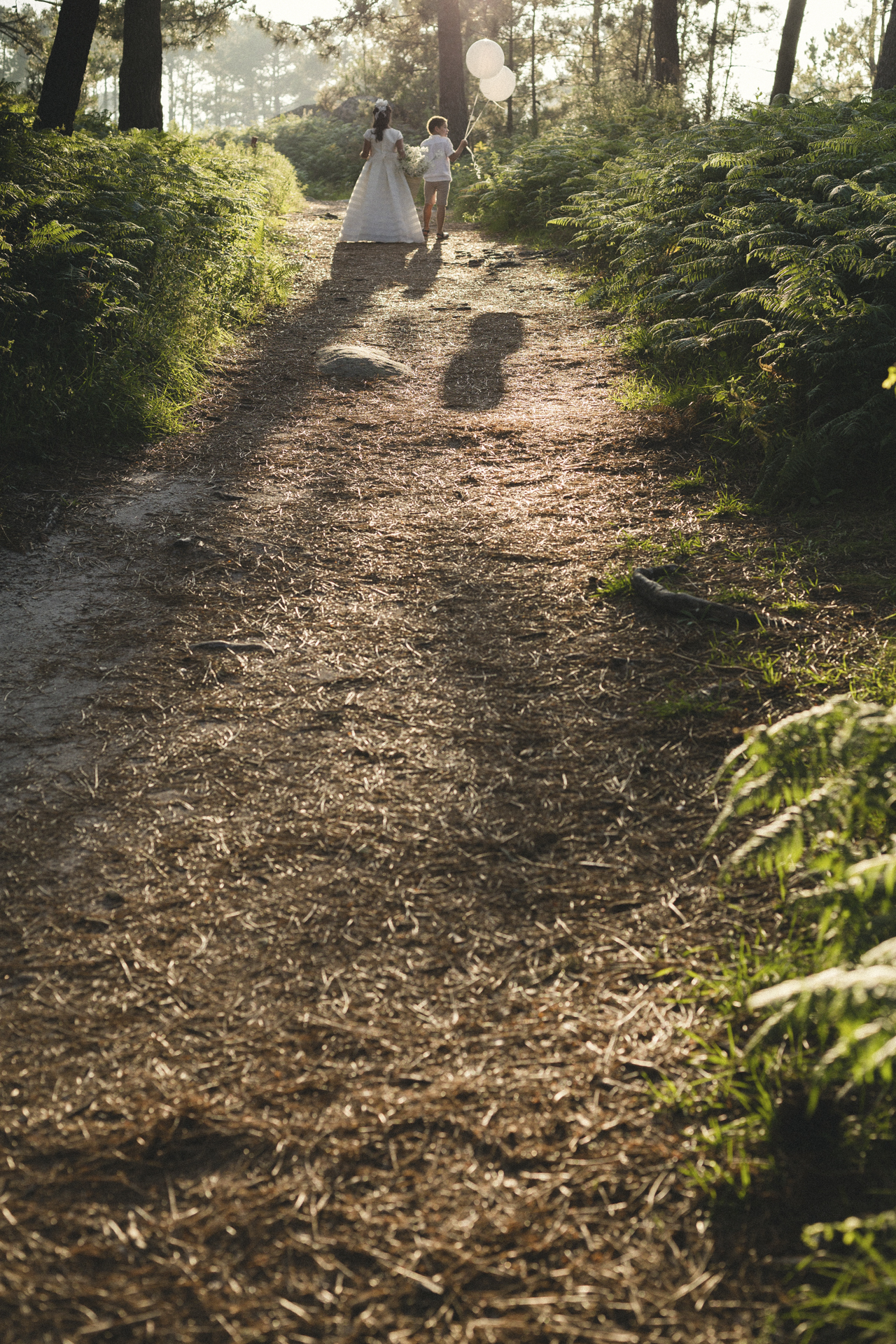 Familia caminando por un camino de bosque, día de comunión