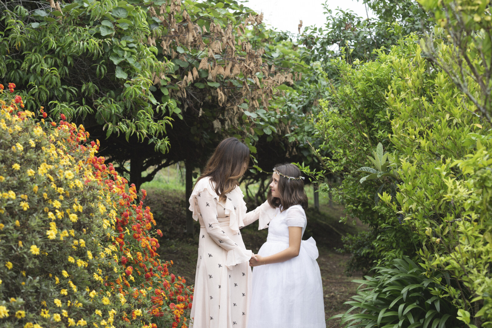 Niñas de comunión con vestido de topos en un jardín