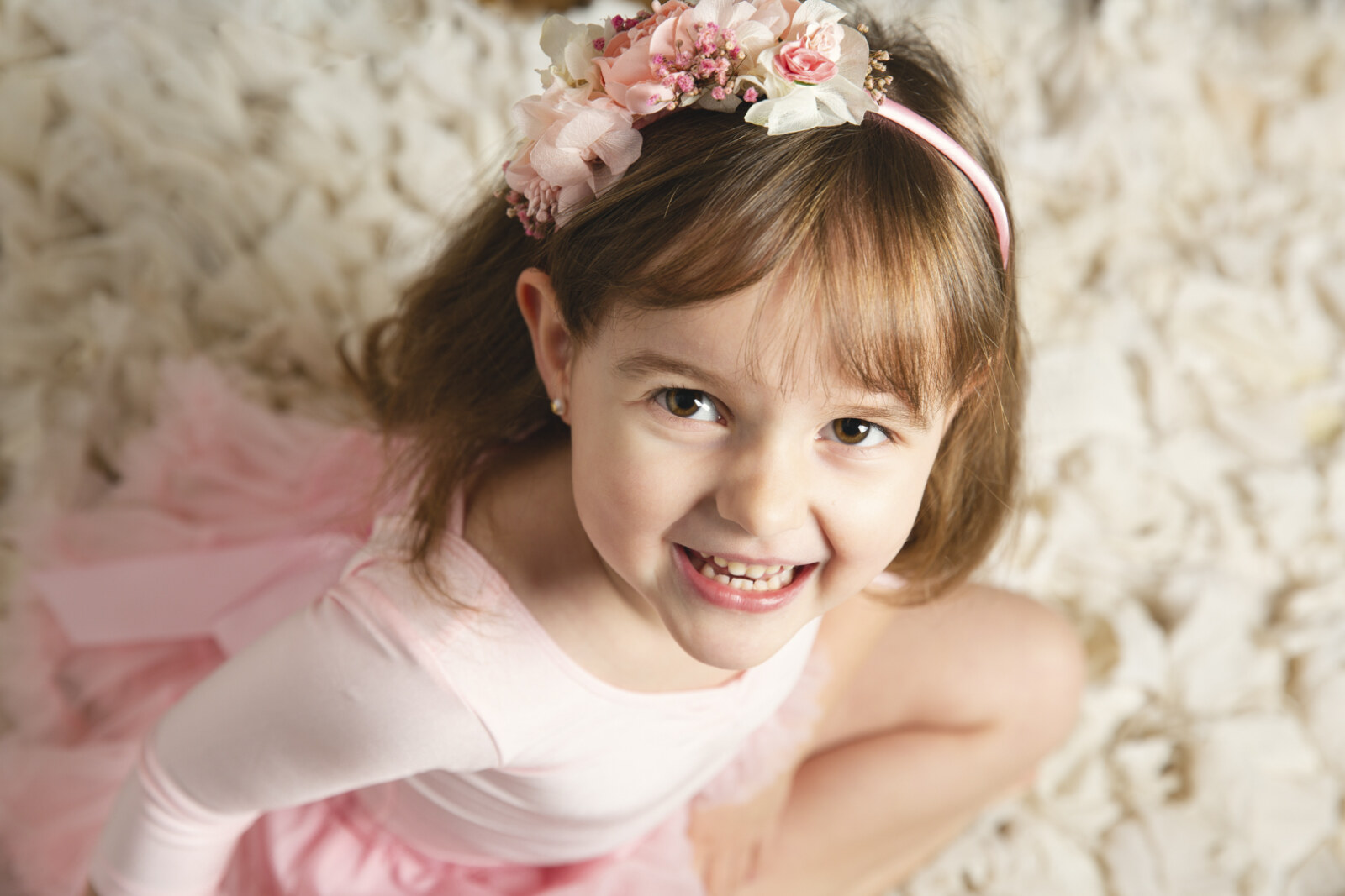 Niña con tutú rosa riendo en sesión de estudio