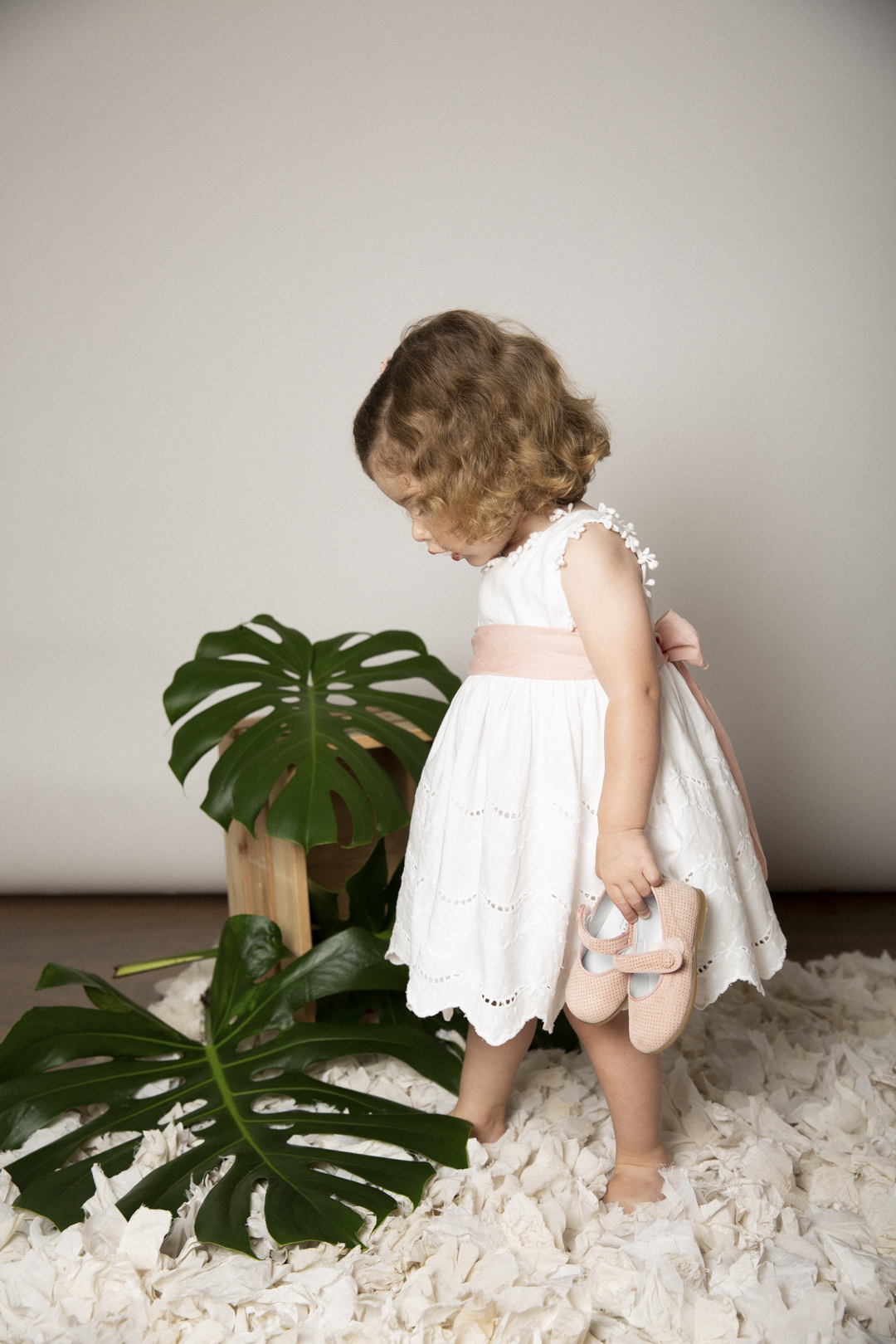Niña con vestido blanco en sesión de estudio infantil
