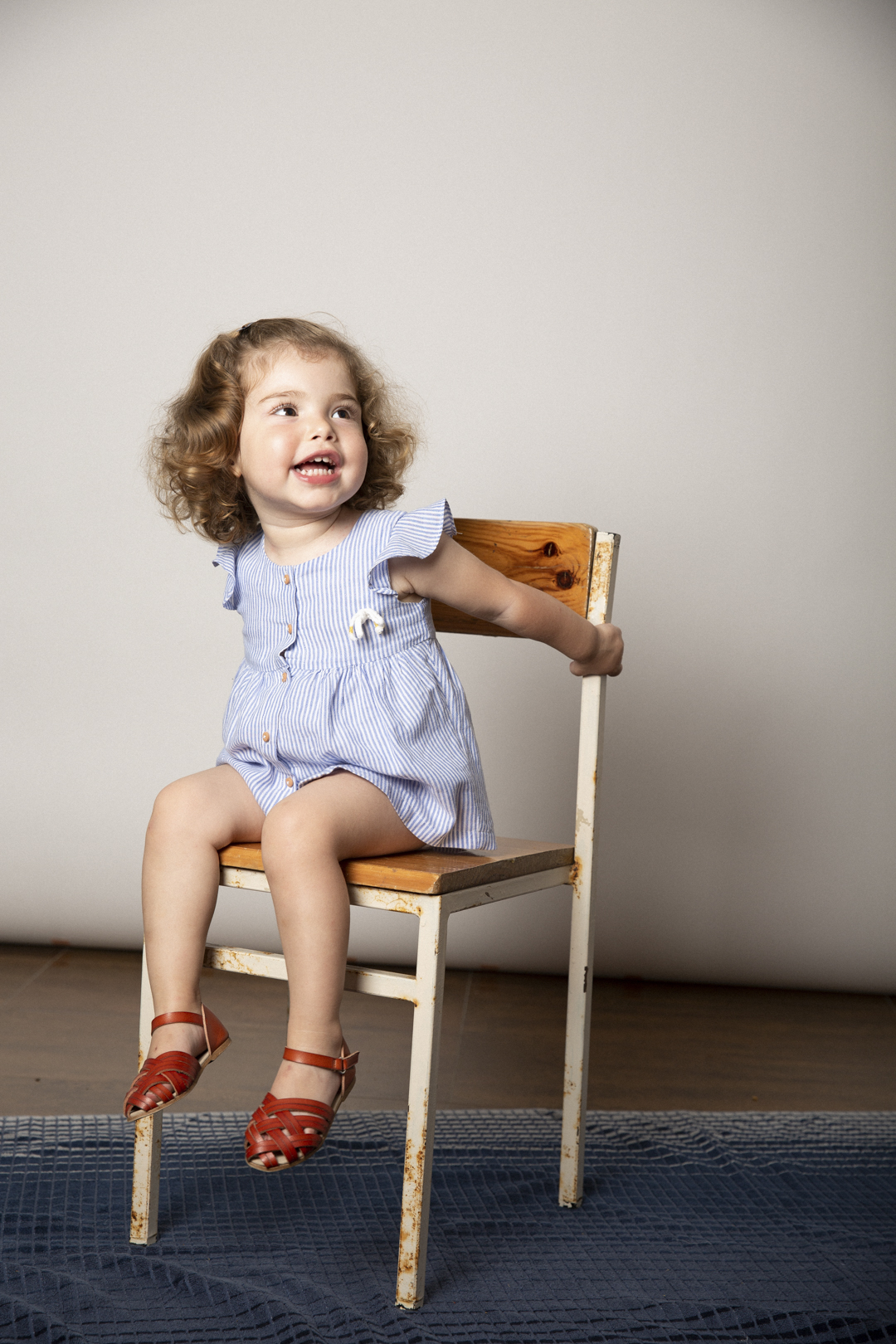 Niña con vestido azul sentada en sesión de estudio