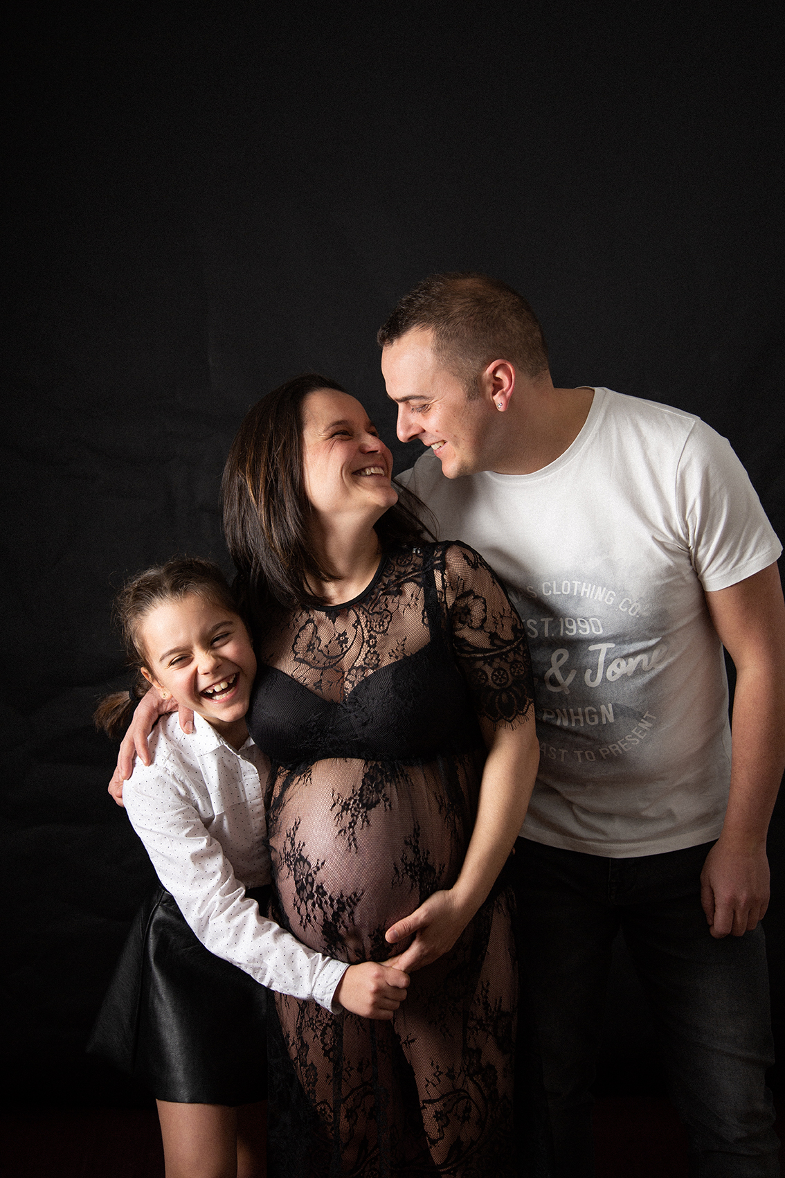 Familia junto a la futura madre en sesión de maternidad