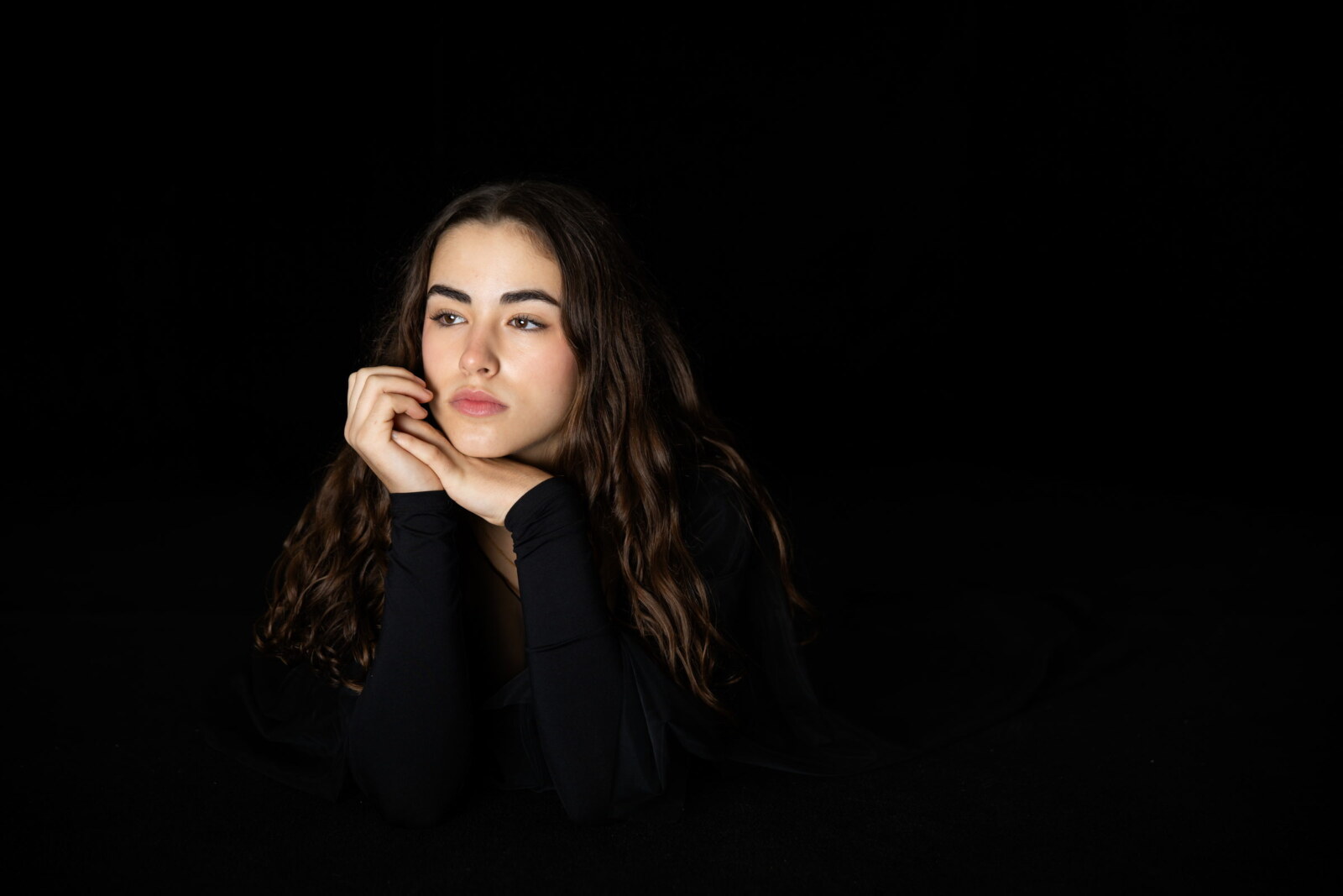 Retrato de estudio con luz suave sobre fondo negro