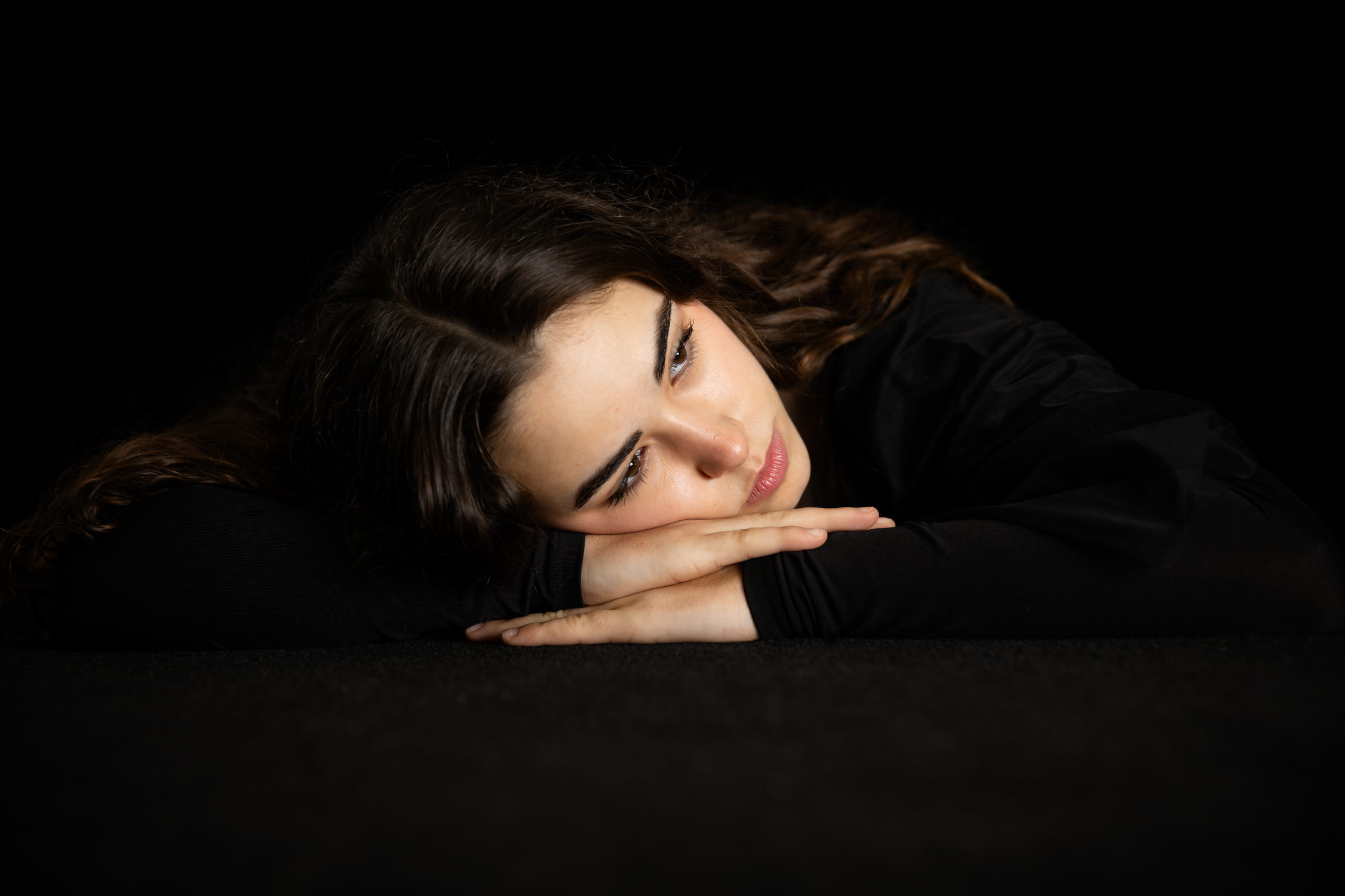 Retrato de perfil sobre fondo negro, con la melena suelta