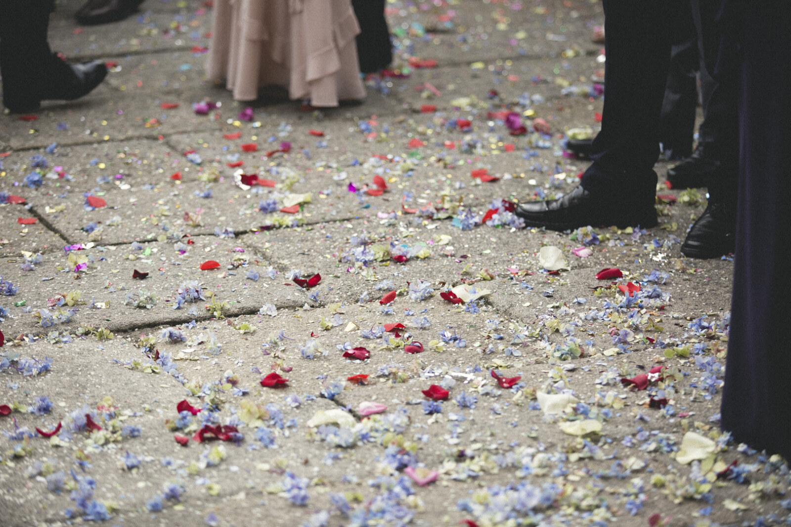 Detalle de pétalos de flores sobre el suelo tras una boda