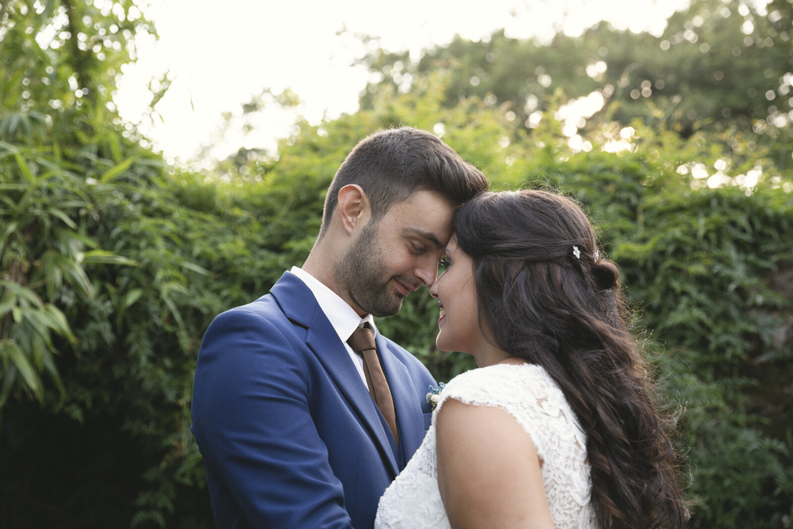 Novios abrazados y sonrientes en el jardín