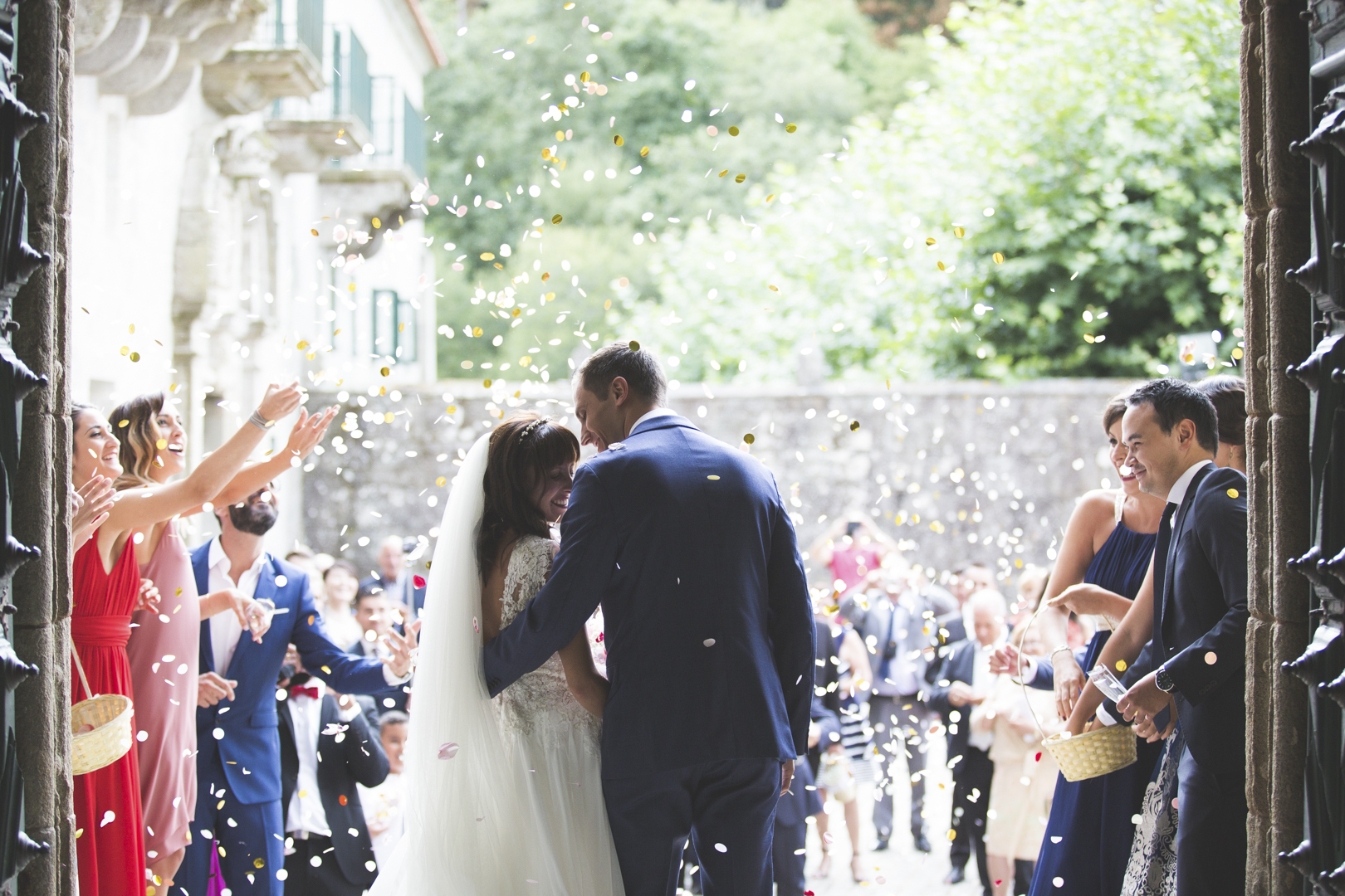 Invitados lanzando confeti a los novios a la salida de la iglesia