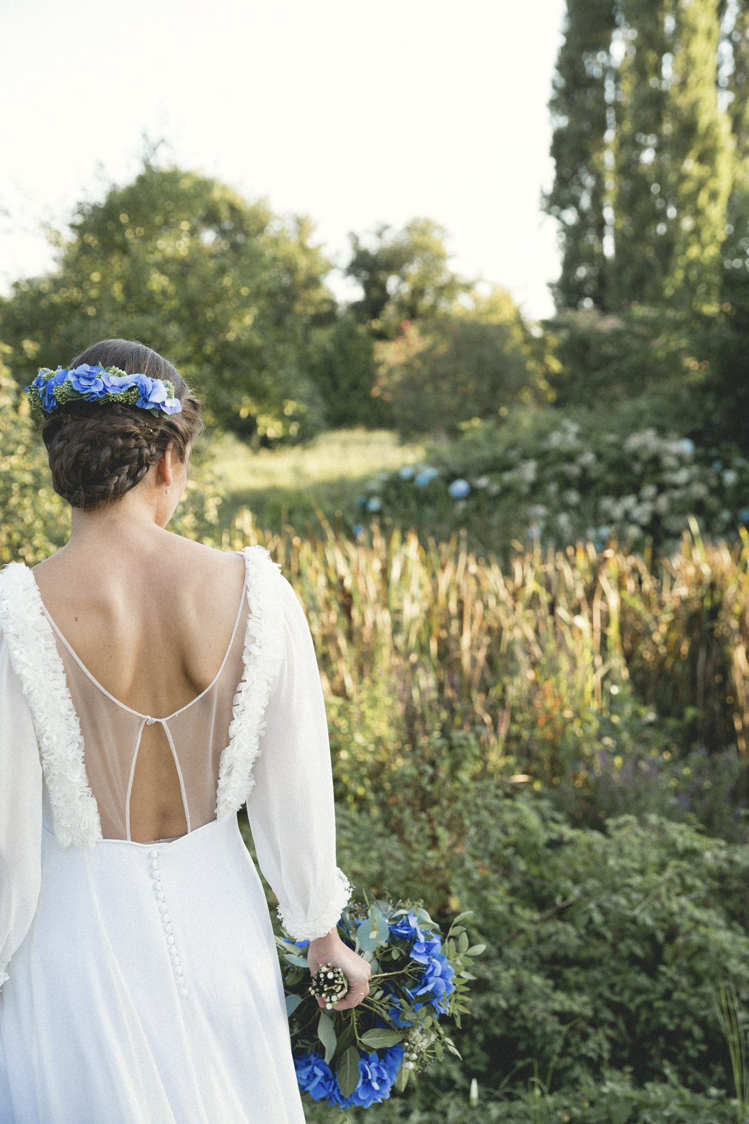 Novia con corona de flores caminando por un prado en Sanxenxo