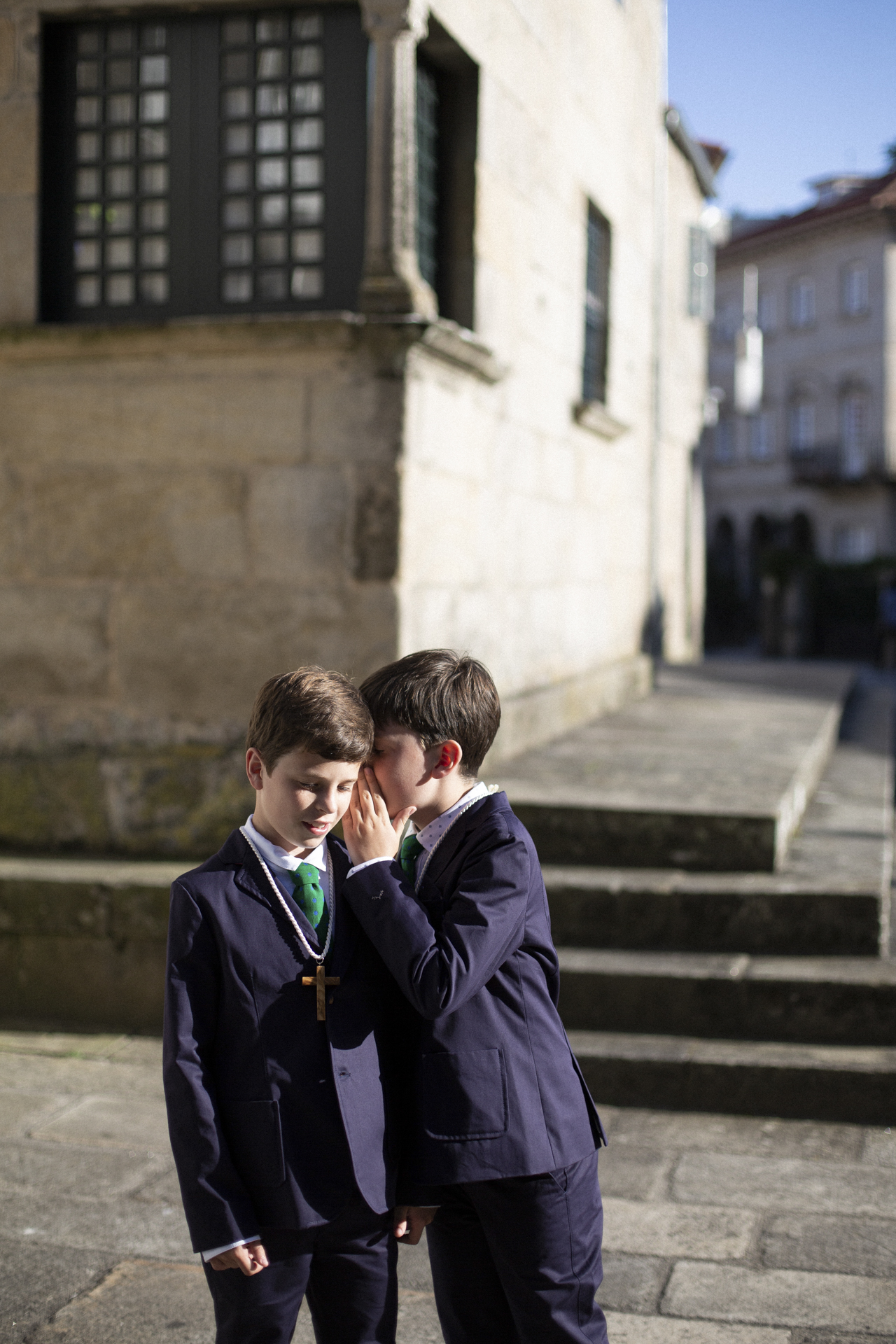 Niños de comunión contándose un secreto