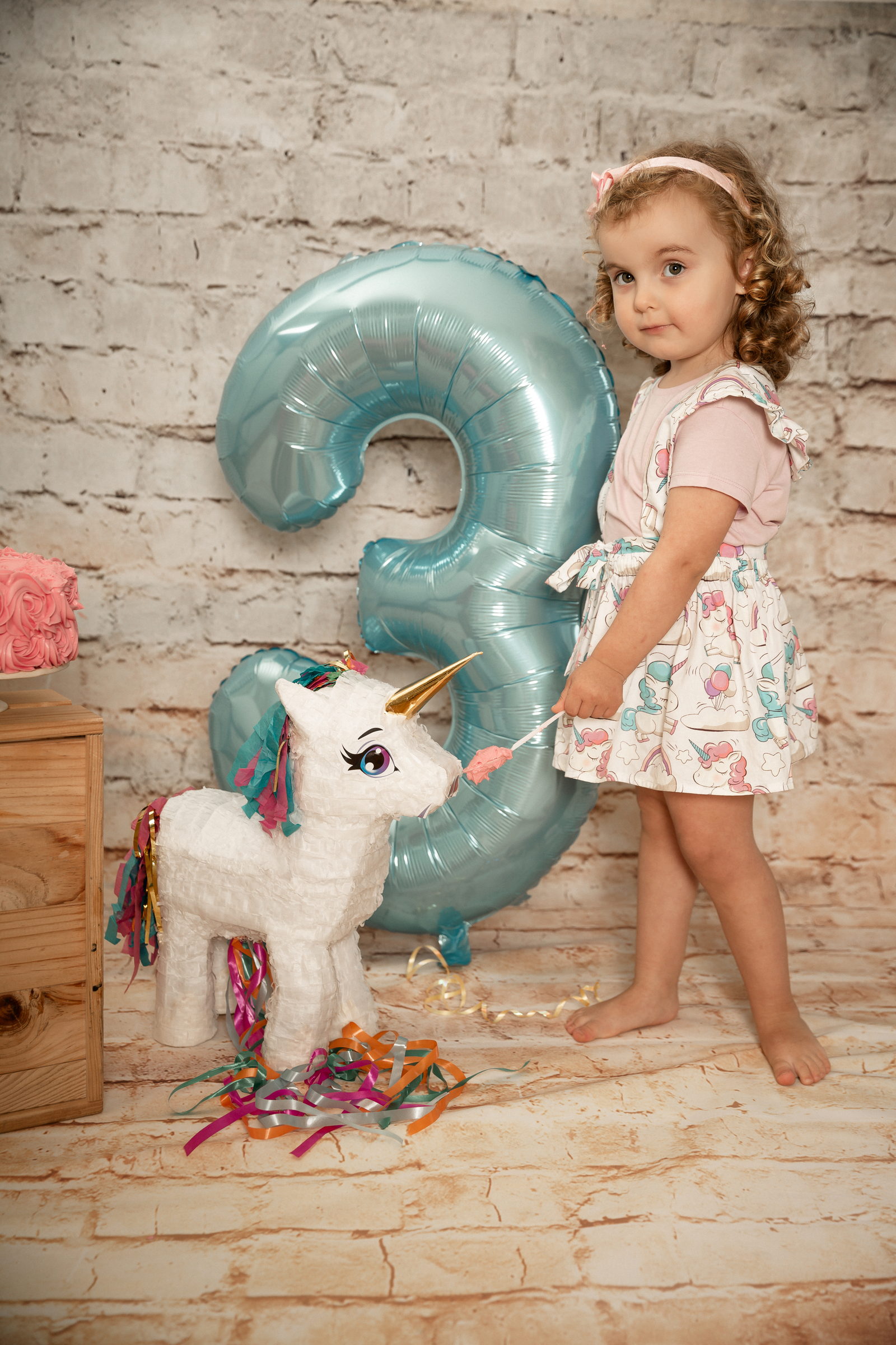 Niña entre confeti celebrando su tercer cumpleaños