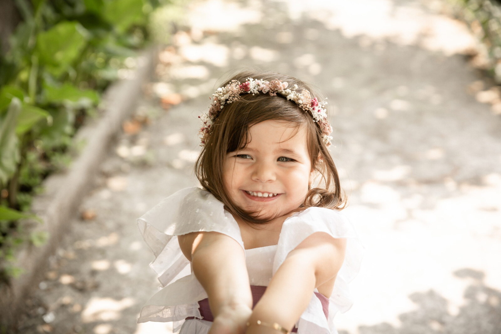 Niña con corona de flores sonriendo a cámara