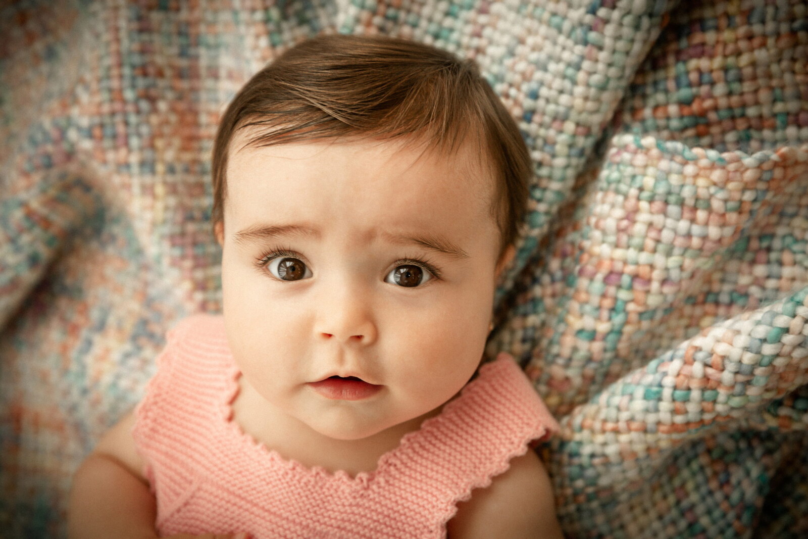 Retrato de bebé sobre una manta de cuadros de colores