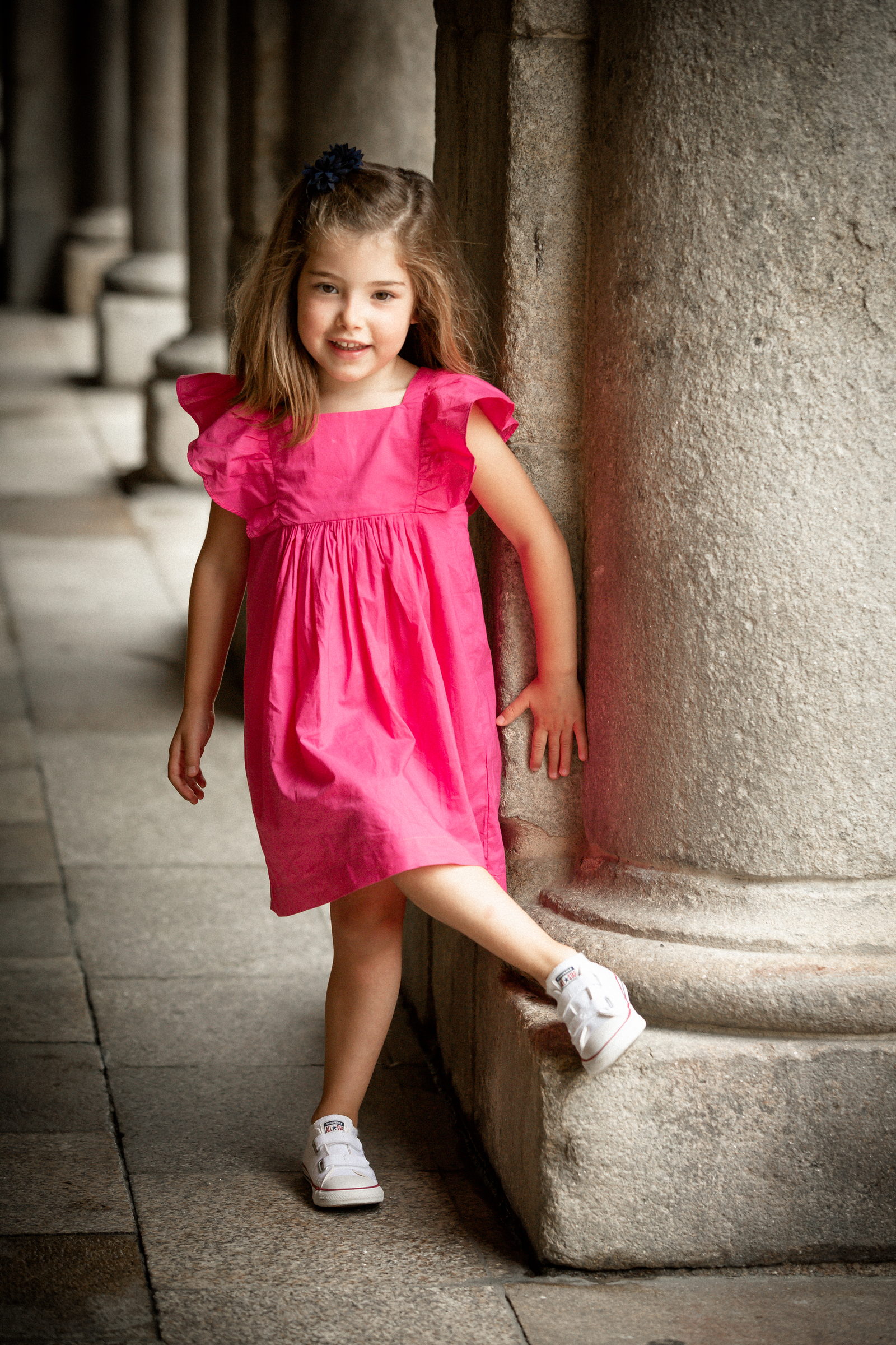 Niña corriendo entre las columnas de un soportal