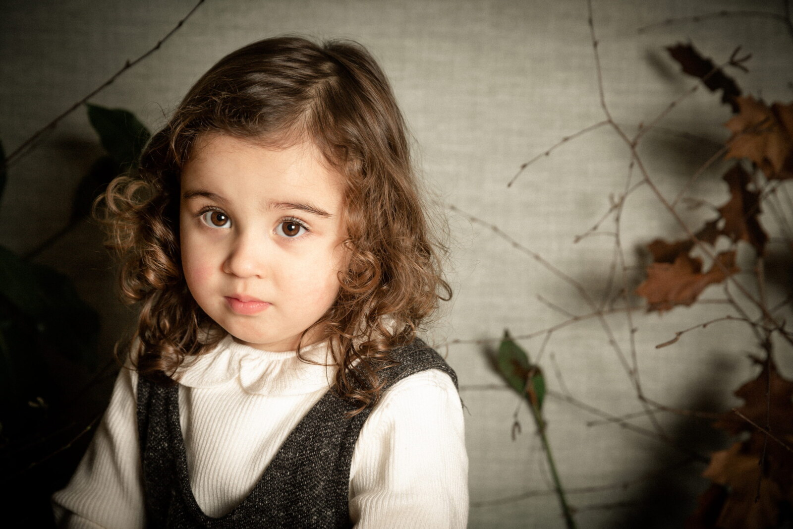 Retrato de una niña de pelo rizado sobre fondo oscuro