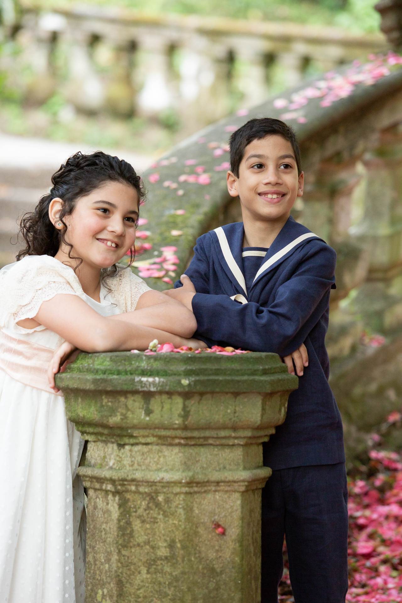 Hermanos apoyados en un pedestal de piedra el día de la comunión