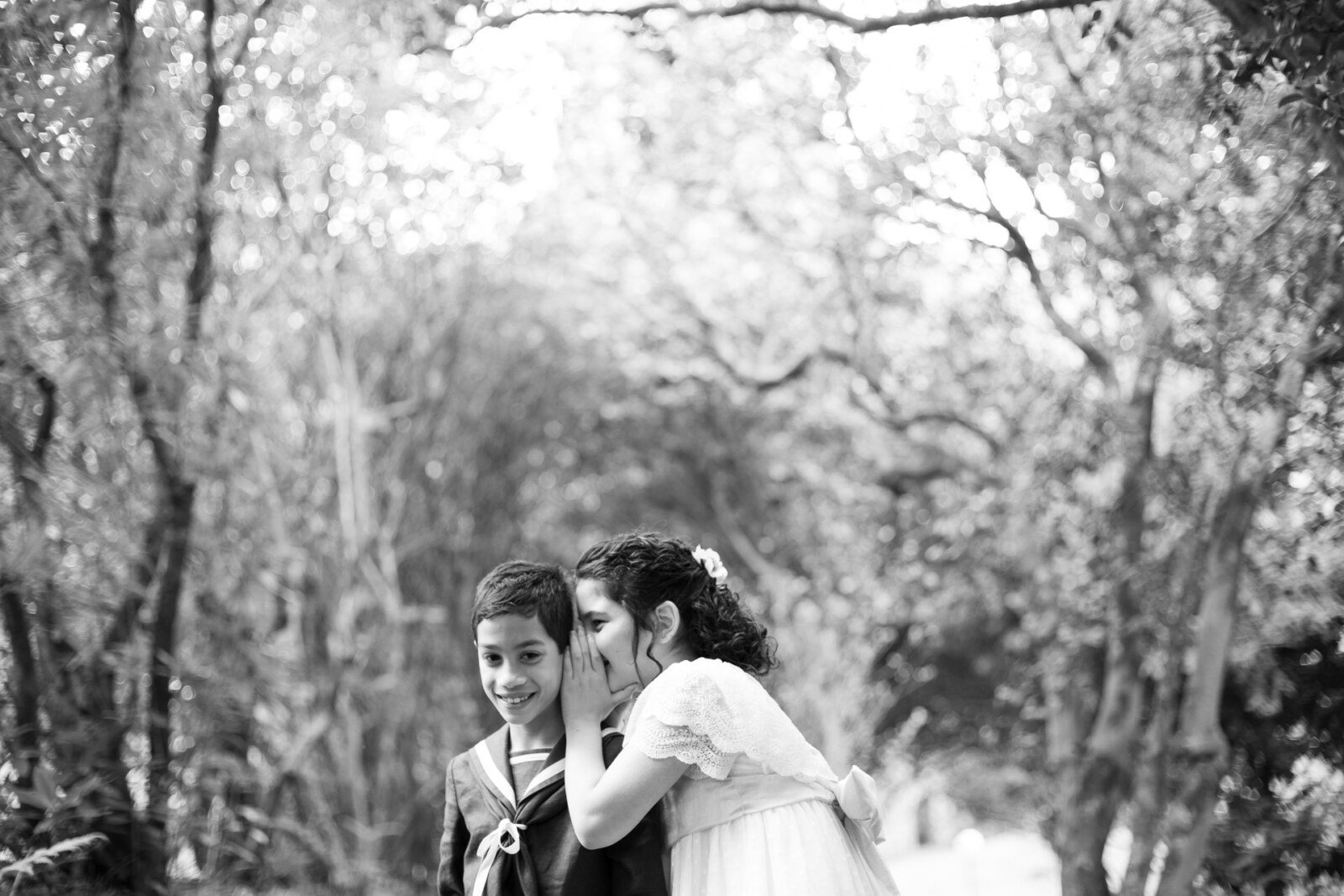 Hermanos cogidos de la mano caminando por el bosque, blanco y negro