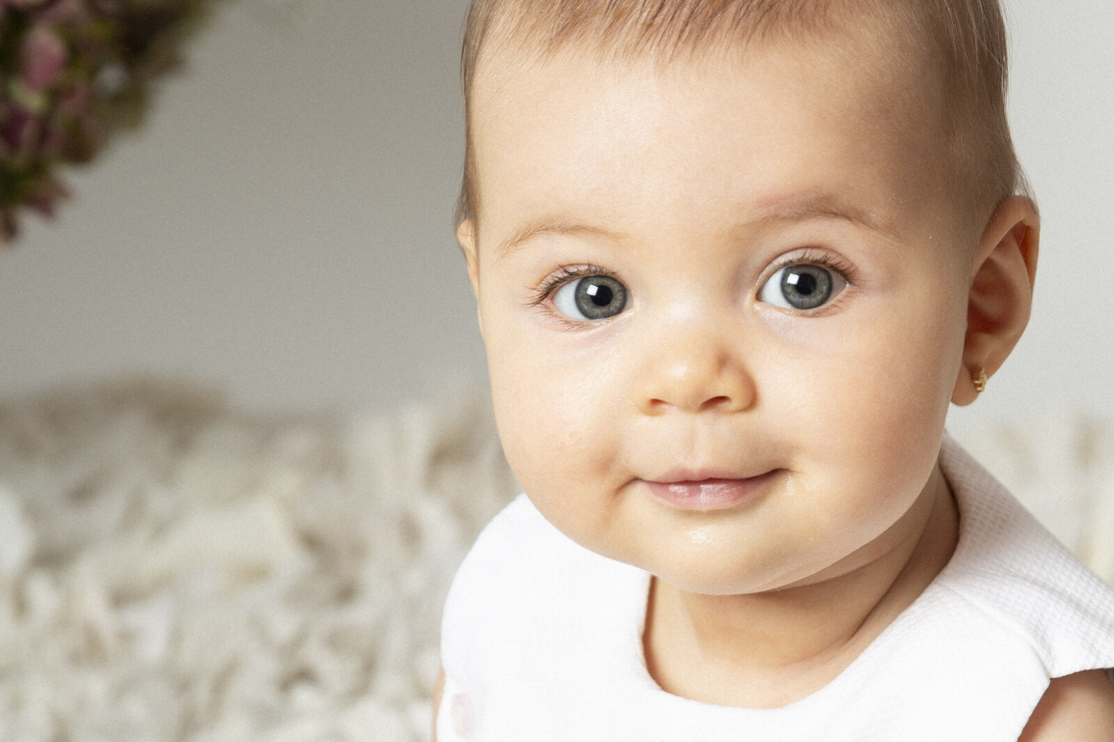Retrato de bebé de ojos azules en sesión de estudio