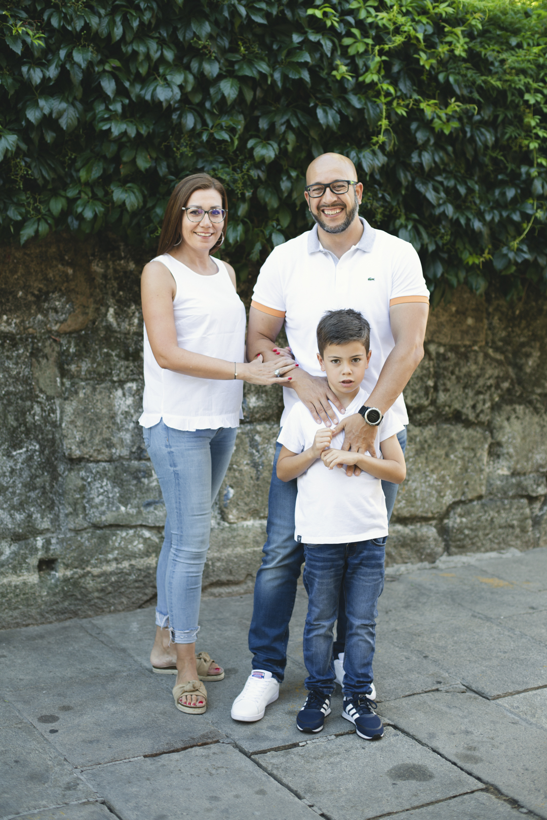 Retrato de familia frente a un muro de hiedra en Pontevedra