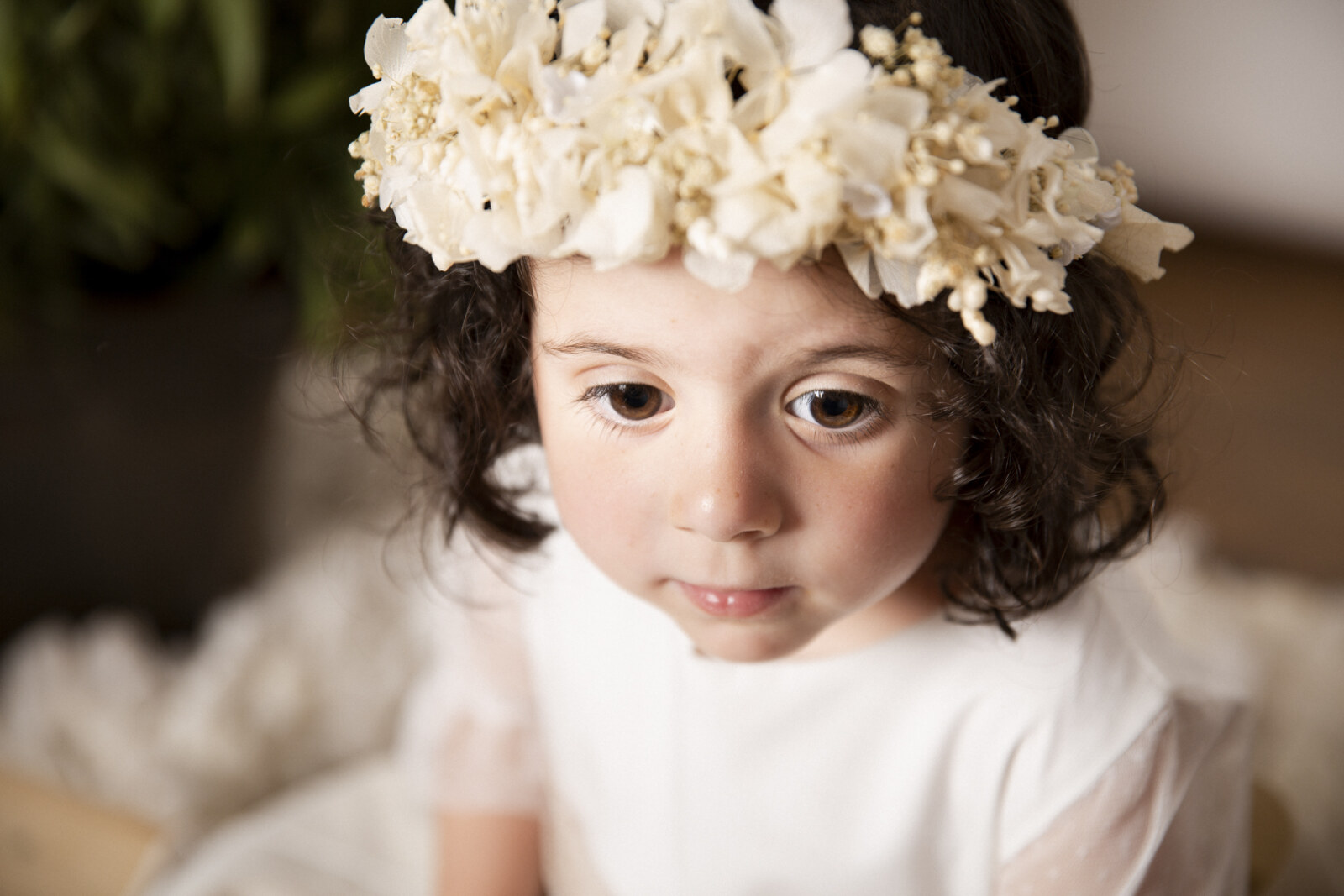 Niña con corona de flores blancas en sesión de estudio