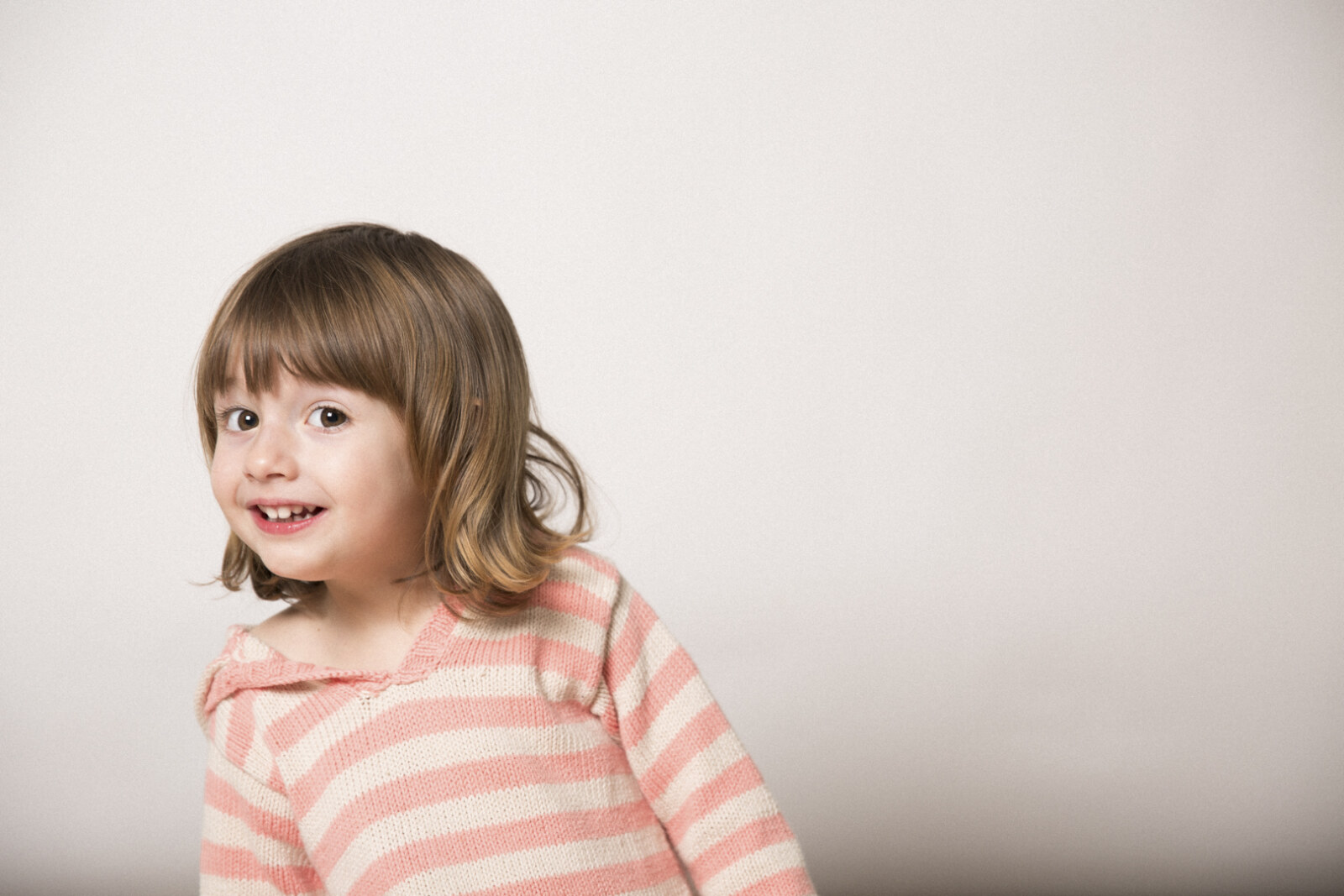 Niña sonriendo en sesión de estudio infantil