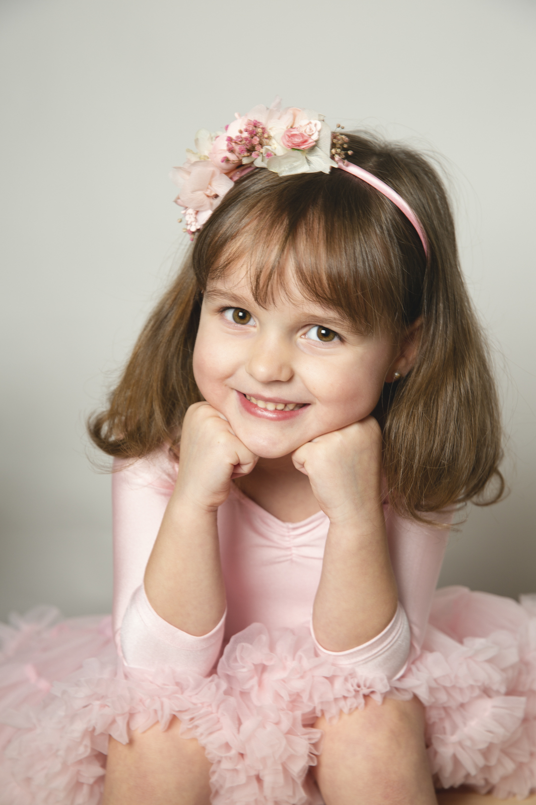Niña sonriente con tutú rosa en estudio
