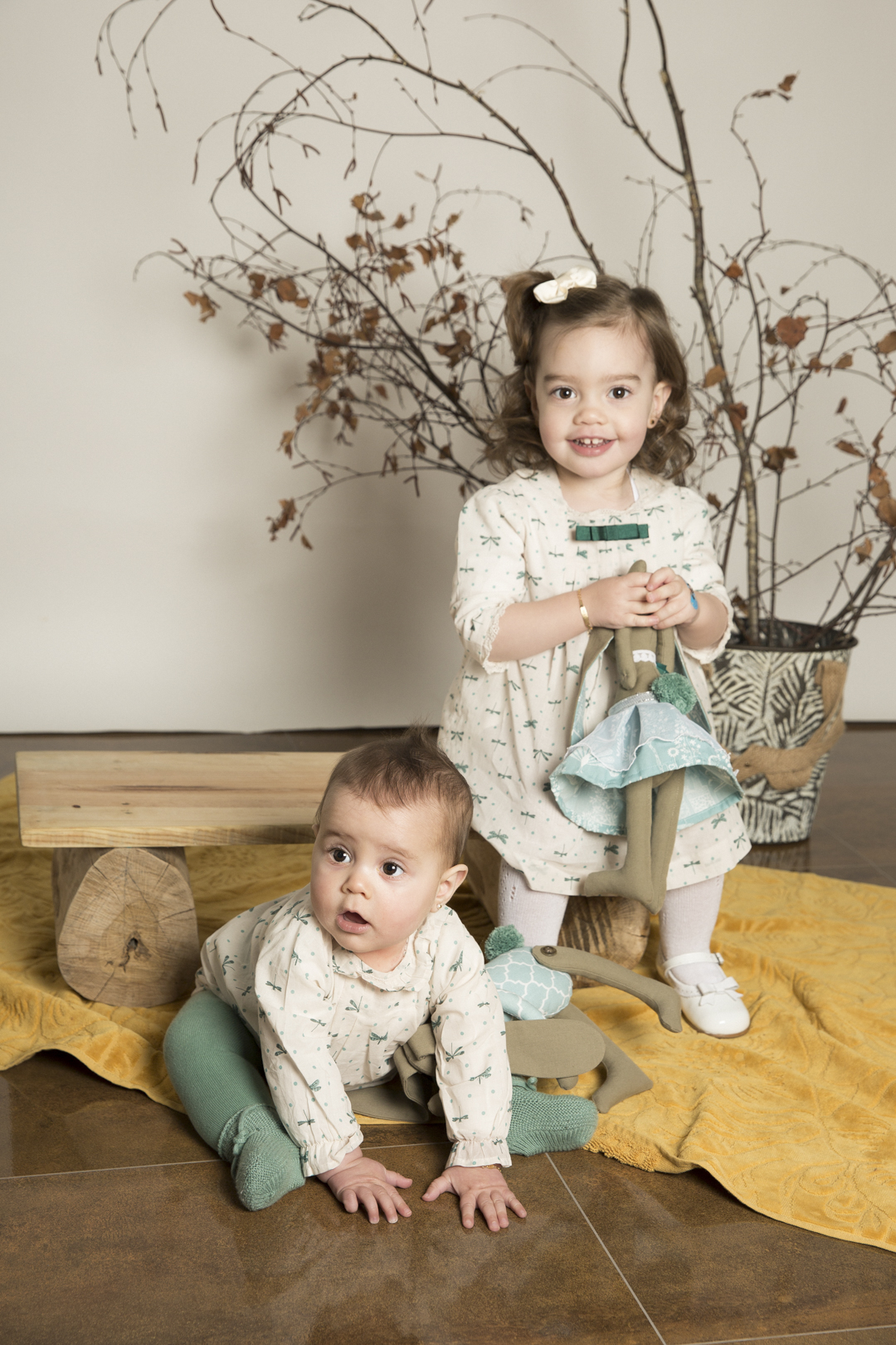 Hermanos, niña y bebé jugando sobre una manta en estudio