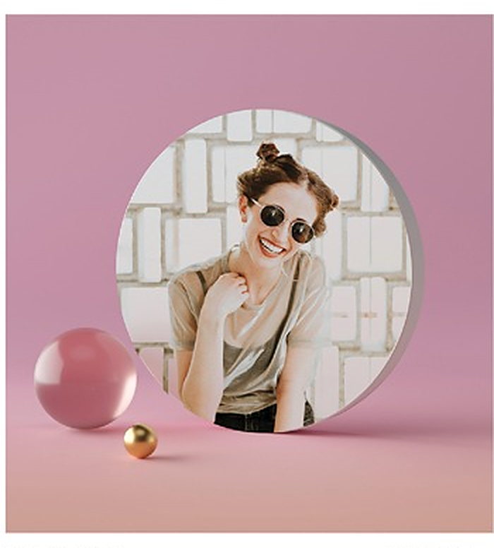 Lienzo fotográfico circular con un retrato, apoyado sobre un fondo rosa